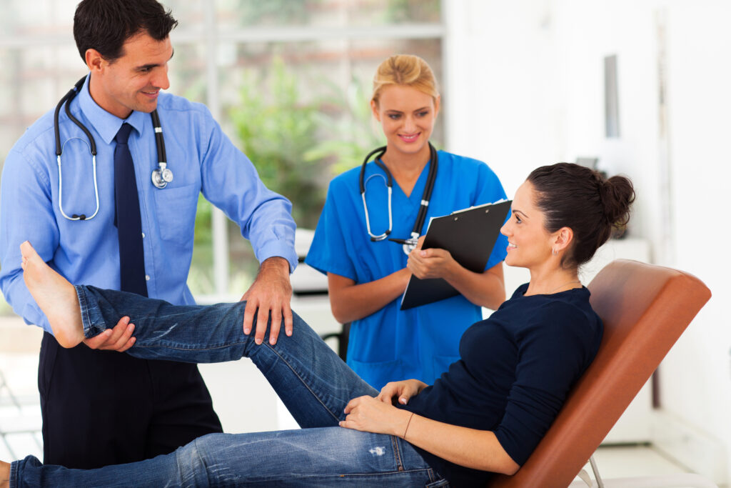orthopaedist examining female patient's leg